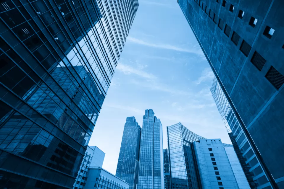 Blueish tinged shot looking up at modern glass office buildings